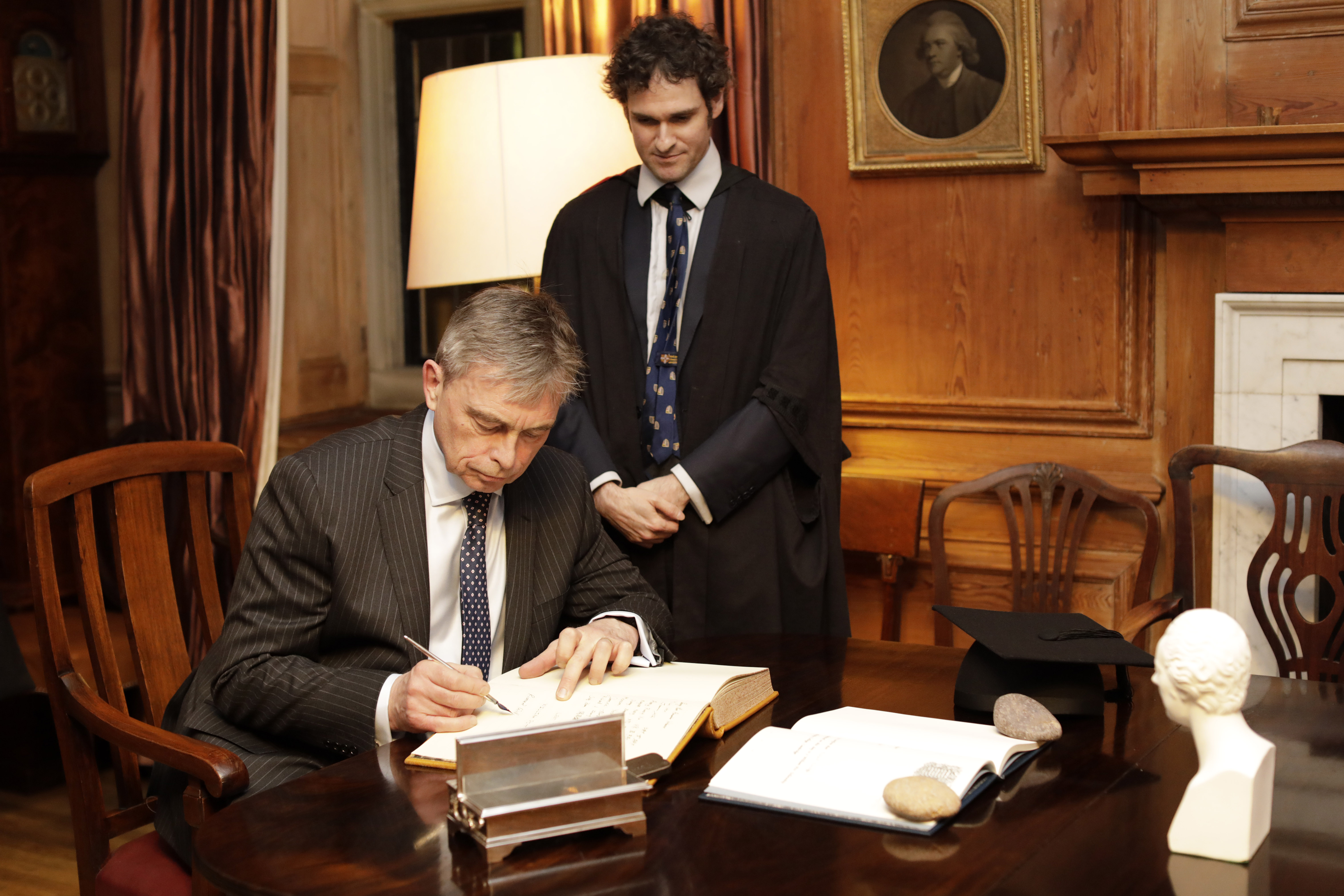 Richard Rawcliffe signs Matriculation Book while the Praelector watches