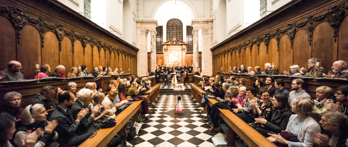 Image of The Pembroke chapel filled with a clapping audience applauding the choir