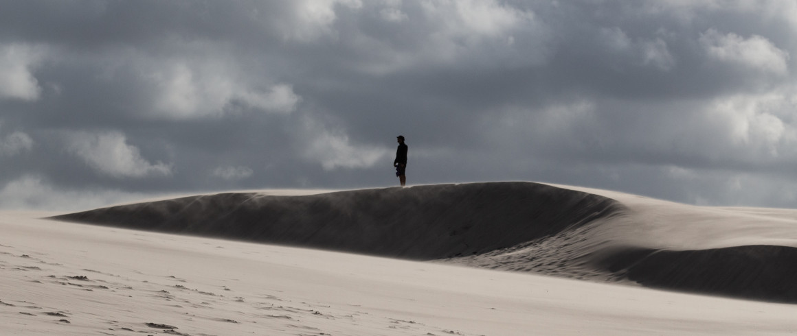 Man standing on a dune by Luca Franzoi Unsplash