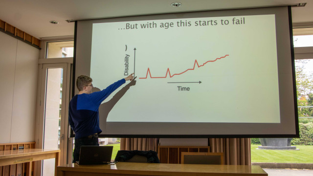 Greg Halliwell points to a graph on the screen
